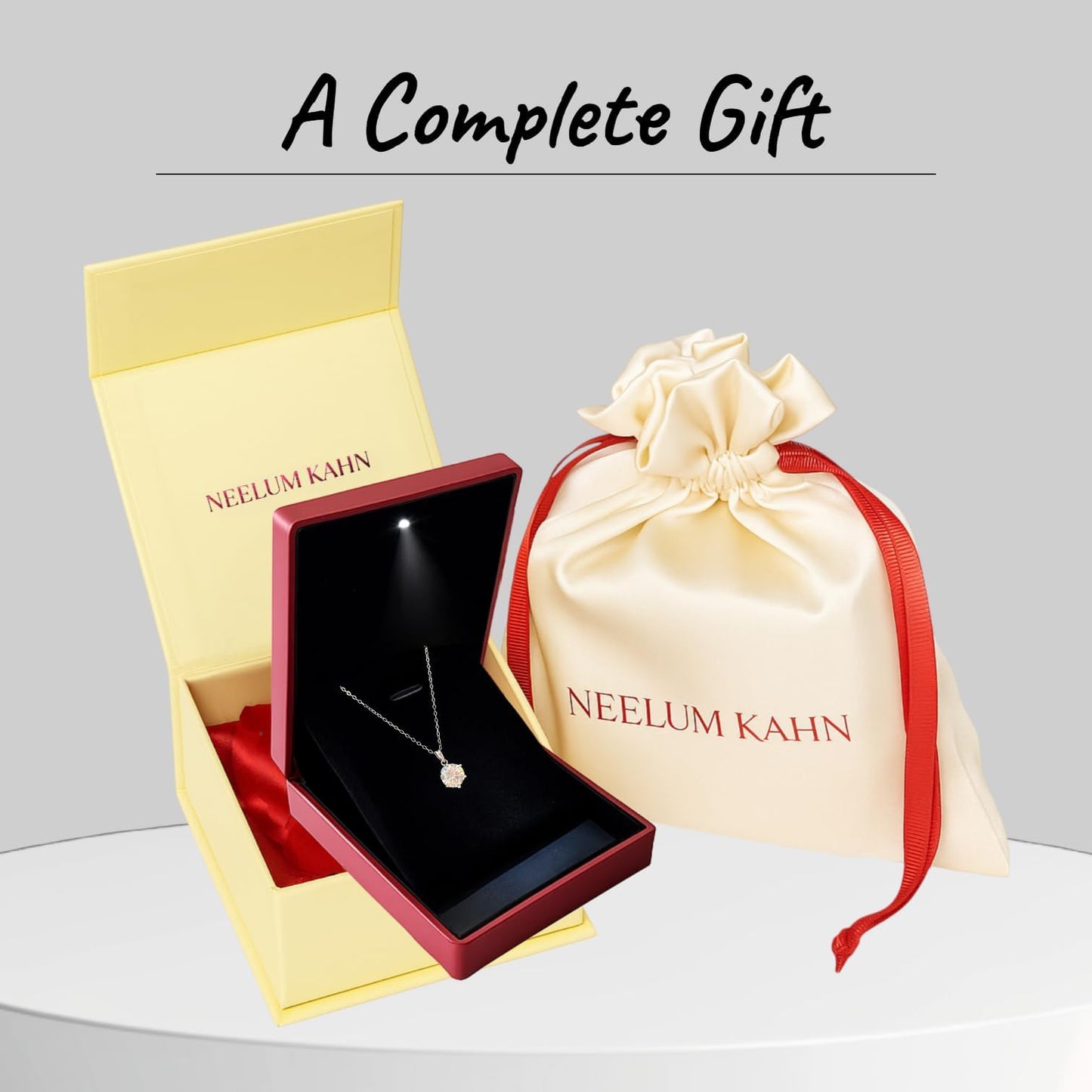 Neelum Kahn jewelry set with necklace in open box and drawstring bag on gray background