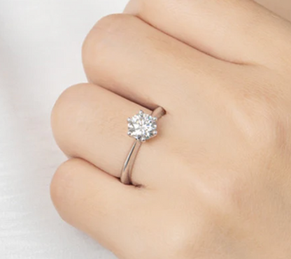 1ct Moissanite Diamond Ring, 925 Sterling Silver, 18K Gold Plated, Round Cut on a finger against a light background