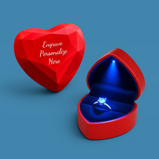 Red heart-shaped ring box with a blue interior on a blue background
